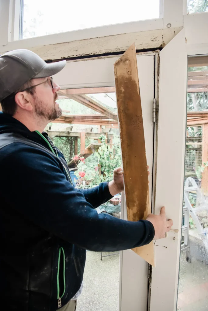 a man holding a piece of wood with signs of wood rot inside while inspecting for dry rot - wood rot repair inspection from North Seattle Handyman